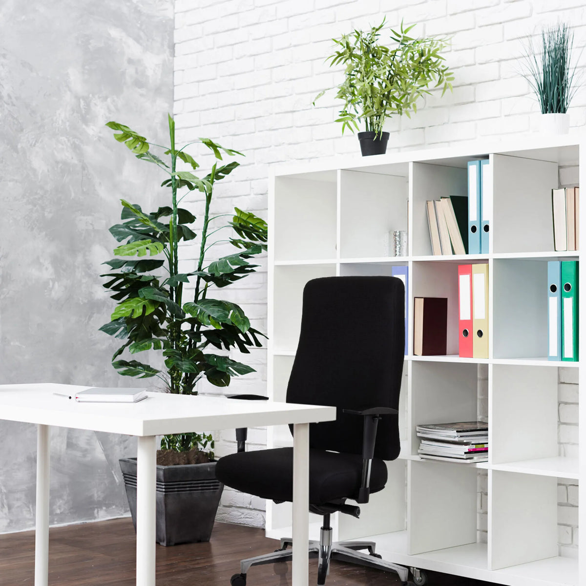 Schwarzer Profi-Bürostuhl FORCOM vor einem weißen Regal und einem weißen Schreibtisch von hjh OFFICE
