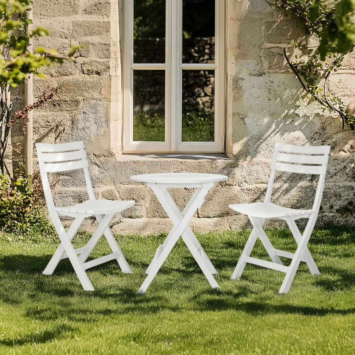Table pliante blanche TRAVANO T avec deux chaises pliantes assorties sur une pelouse verte de hjh LIVING