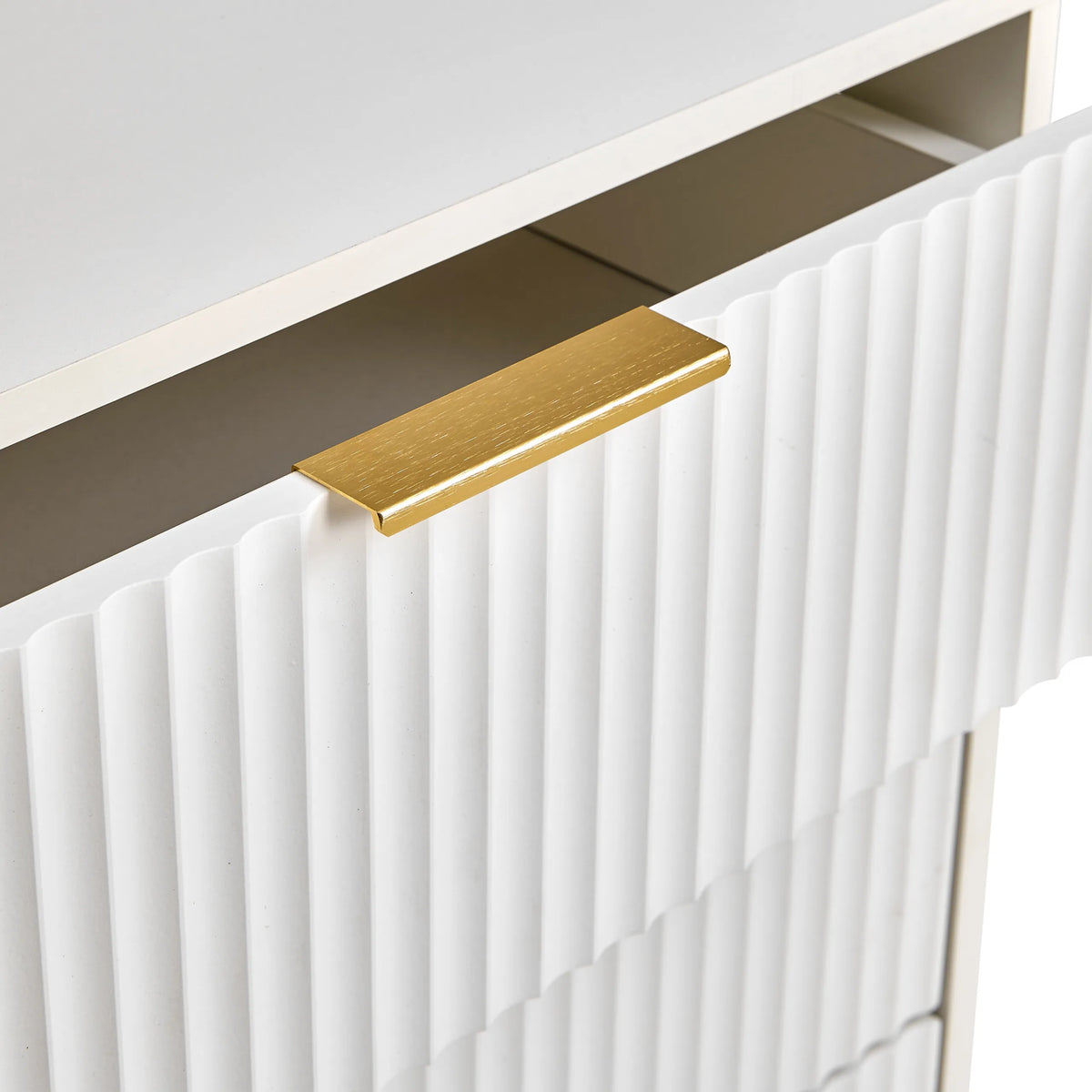 Poignée dorée sur une façade blanche à structure striée de la commode Hjelle K de hjh LIVING