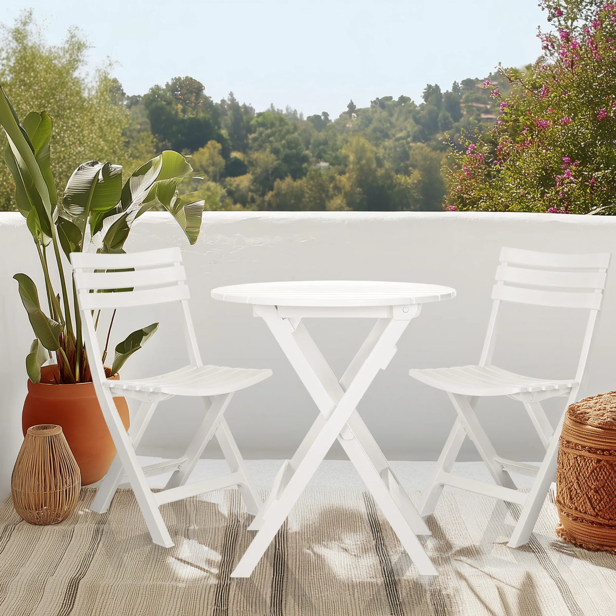 Table pliante blanche TRAVANO T avec deux chaises pliantes assorties sur une terrasse de hjh LIVING