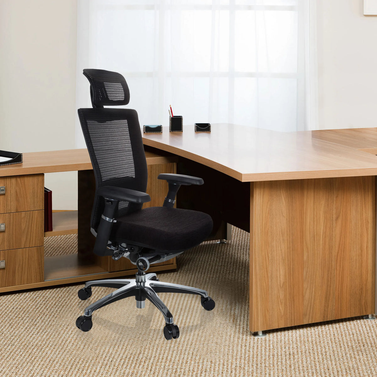 Siège de bureau haut de gamme NOVA PRO I noir avec dossier en maille et appui-tête devant un bureau de hjh OFFICE