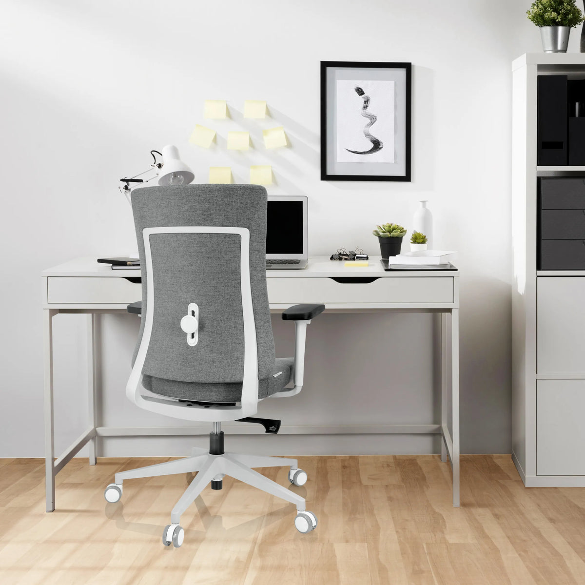 Siège de bureau de qualité professionnelle COMFIO WP gris avec structure et roulettes blanches devant un bureau de hjh OFFICE