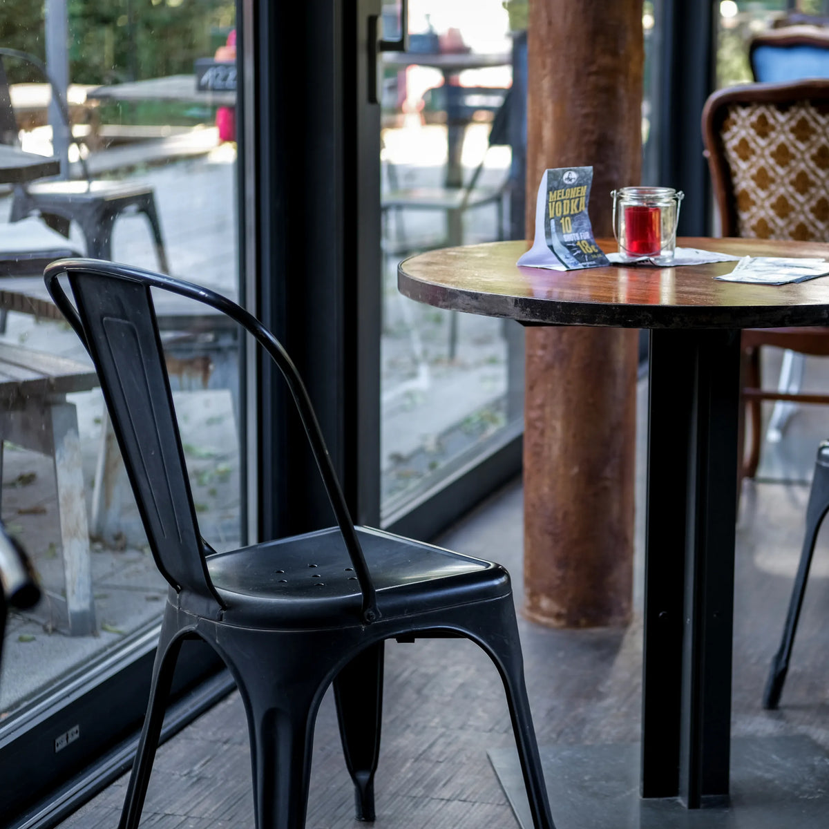 Chaise de bistrot noire VANTAGGIO BRUSH avec dossier courbé à une table ronde de hjh OFFICE