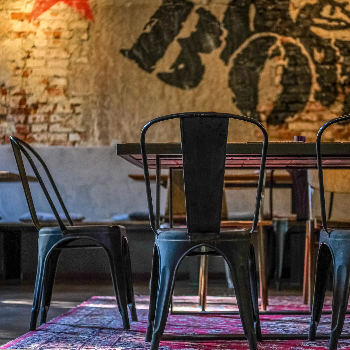 Vue arrière d'une chaise de bistrot VANTAGGIO BRUSH en métal noir à une table de hjh OFFICE
