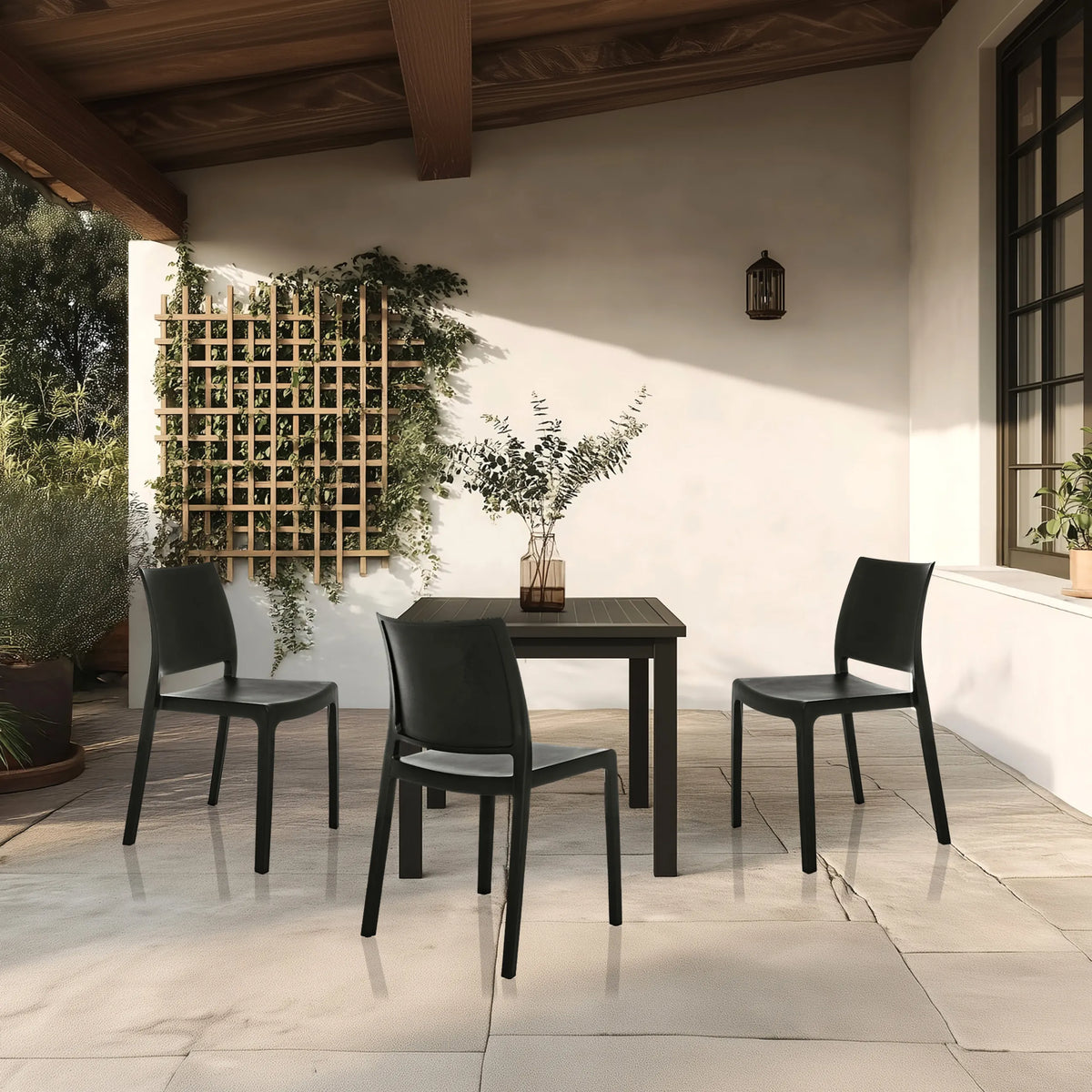 Trois chaises d'extérieur noires T37 V avec table assortie sur une terrasse de hjh LIVING