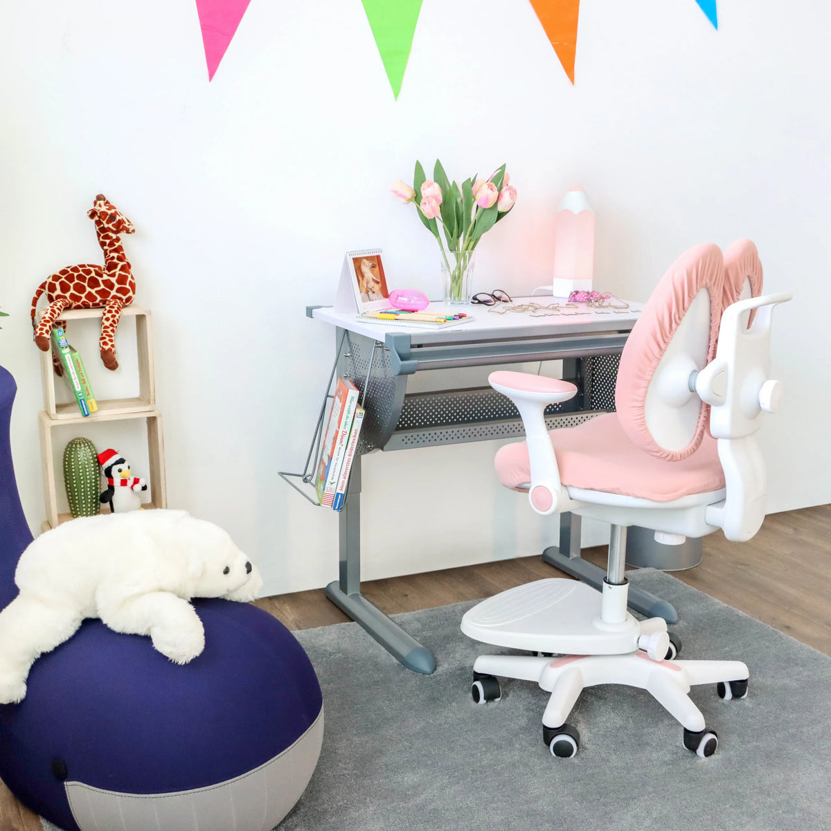 Chaise pour enfants KID WING rose avec structure blanche et roulettes devant un bureau pour enfants de hjh OFFICE