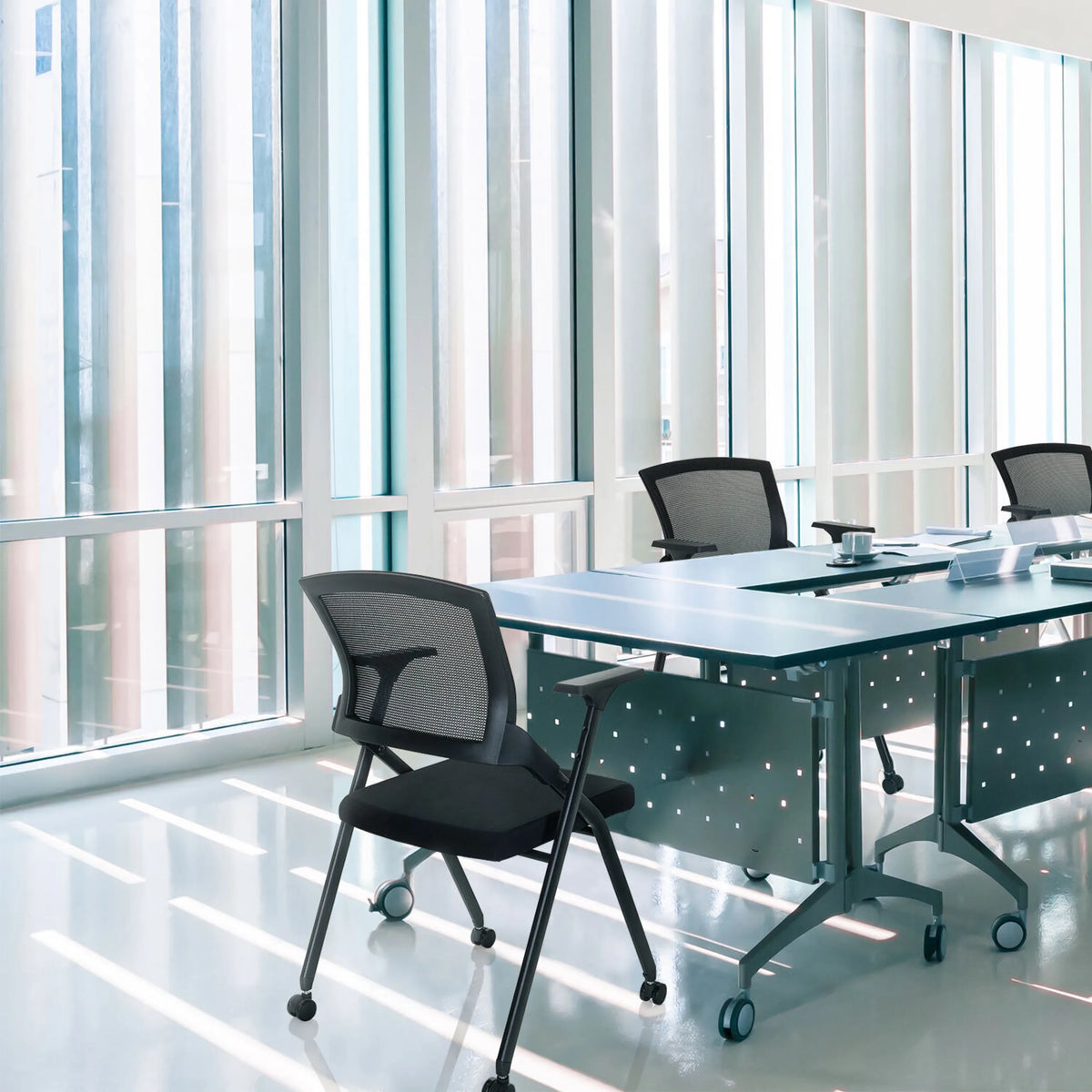 Chaise pliante PRIORITY II en noir avec dossier en maille à une table de conférence de hjh OFFICE