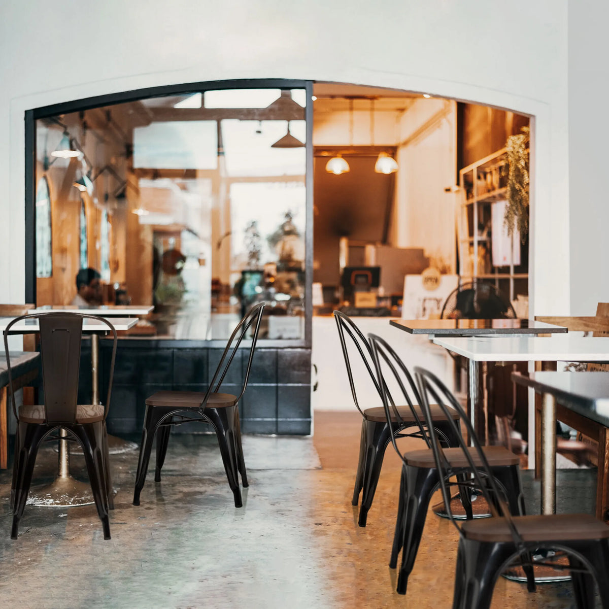 Chaises de bistrot noires VANTAGGIO COMFORT W avec structure métallique à des tables dans un café de hjh OFFICE