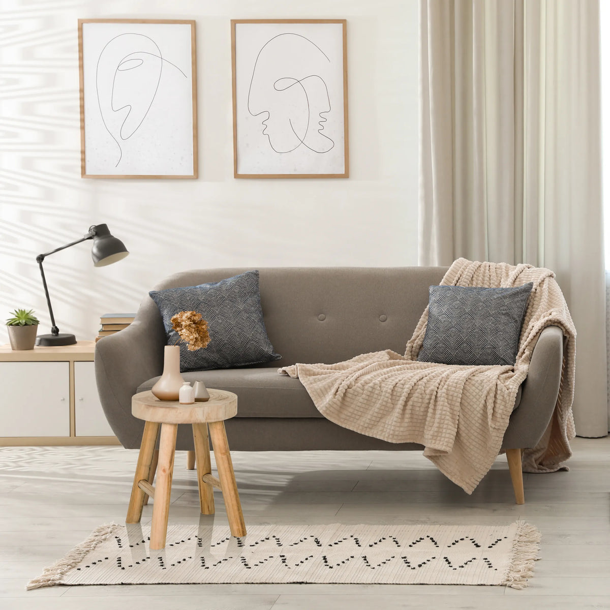 Tabouret RUSTIKO W en bois marron utilisé comme table d'appoint devant un canapé gris de hjh LIVING