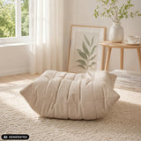 Pouf Sitzolo Podi beige avec structure matelassée sur un tapis clair de hjh LIVING (image générée par IA)