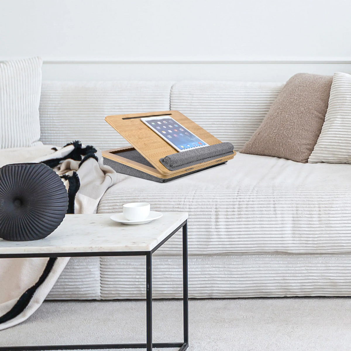 Support pour ordinateur portable COMFILAP III marron avec coussin gris sur un canapé clair de hjh OFFICE