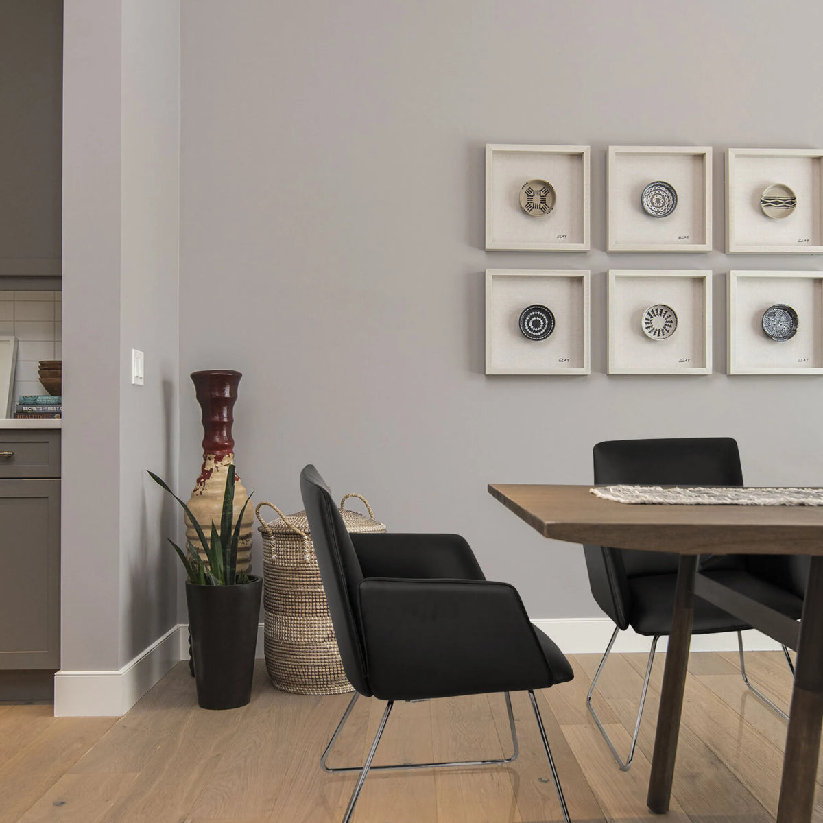 Chaise rembourrée noire DESIGNIA V avec des pieds métalliques fins à une table en bois de hjh OFFICE