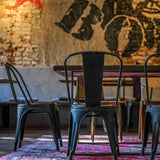 Rückansicht eines schwarzen Bistrostuhls VANTAGGIO BRUSH aus Metall an einem Tisch von hjh OFFICE