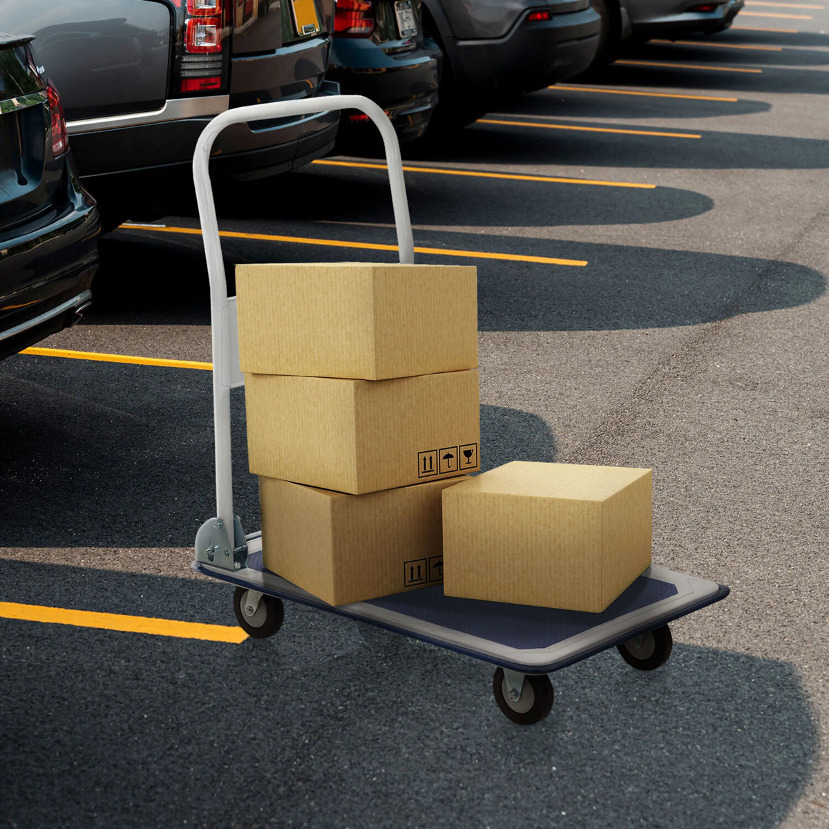 Chariot à plateforme CARRY bleu et blanc avec trois cartons chargés sur un parking de hjh OFFICE