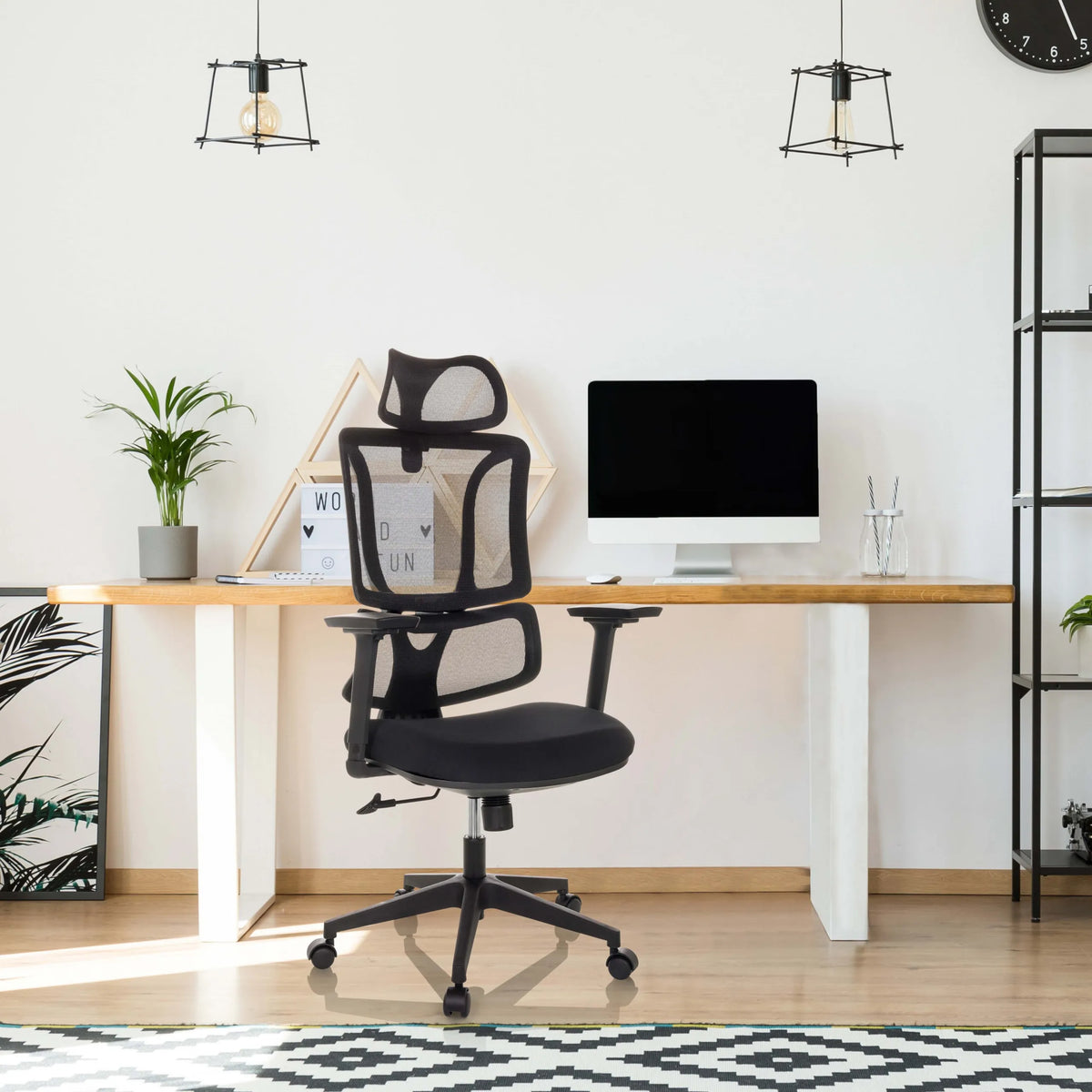 Schwarzer Homeoffice-Bürostuhl ERGOMY mit Netzrückenlehne und Armlehnen an einem Schreibtisch von MyBuero