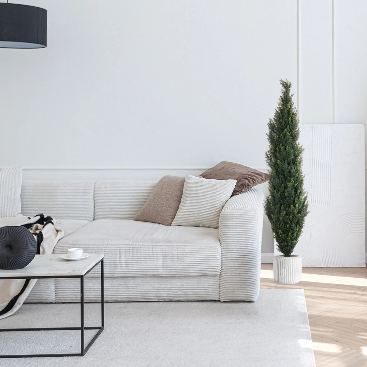 Plante artificielle verte CEDRUS dans un pot blanc à côté d'un canapé blanc de hjh OFFICE