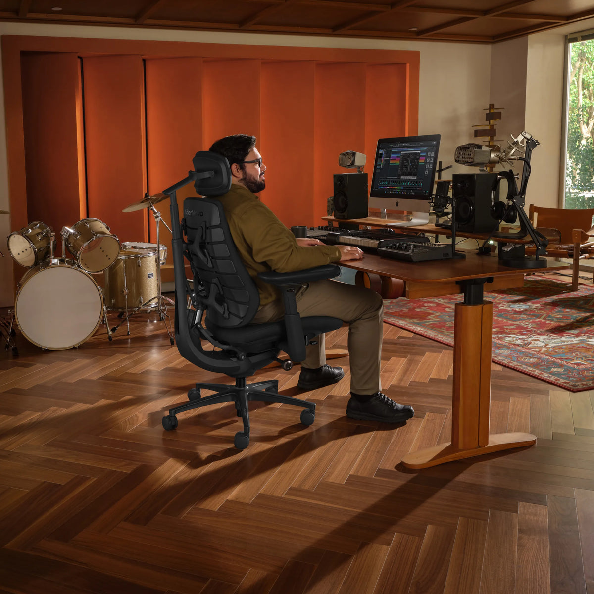 Chaise de bureau LiberNovo Maxis Airflow en graphite à un bureau réglable en hauteur dans un studio de musique de Libernovo