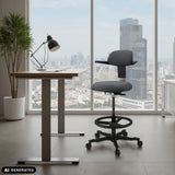 Chaise de travail TOP WORK 40 gris foncé avec repose-pieds et roulettes devant une fenêtre de hjh OFFICE (image générée par IA)