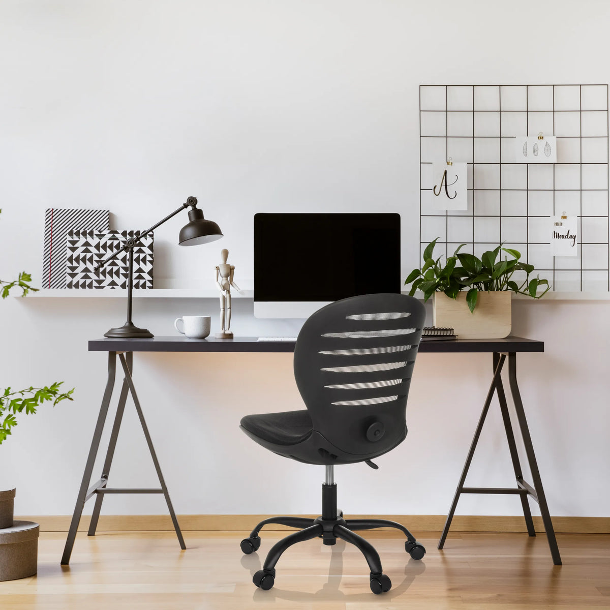 Siège de bureau à domicile CASLA noir avec dossier incurvé et roulettes devant un bureau de hjh OFFICE
