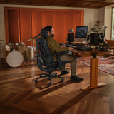 Chaise de bureau LiberNovo Maxis Elektric en graphite dans un studio de musique avec bureau et batterie de Libernovo