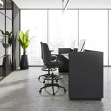 Deux chaises de comptoir noires NESTORA WORK avec repose-pieds et roulettes à un bureau moderne de hjh OFFICE