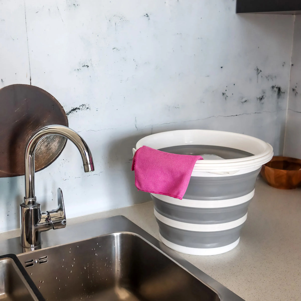 Conteneur pliable CLEAN SILR gris et blanc avec un chiffon rose sur un plan de travail à côté d'un évier de hjh OFFICE