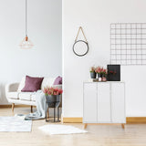 Commode blanche ESTHA avec deux portes et pieds en bois clair dans un salon lumineux de hjh LIVING