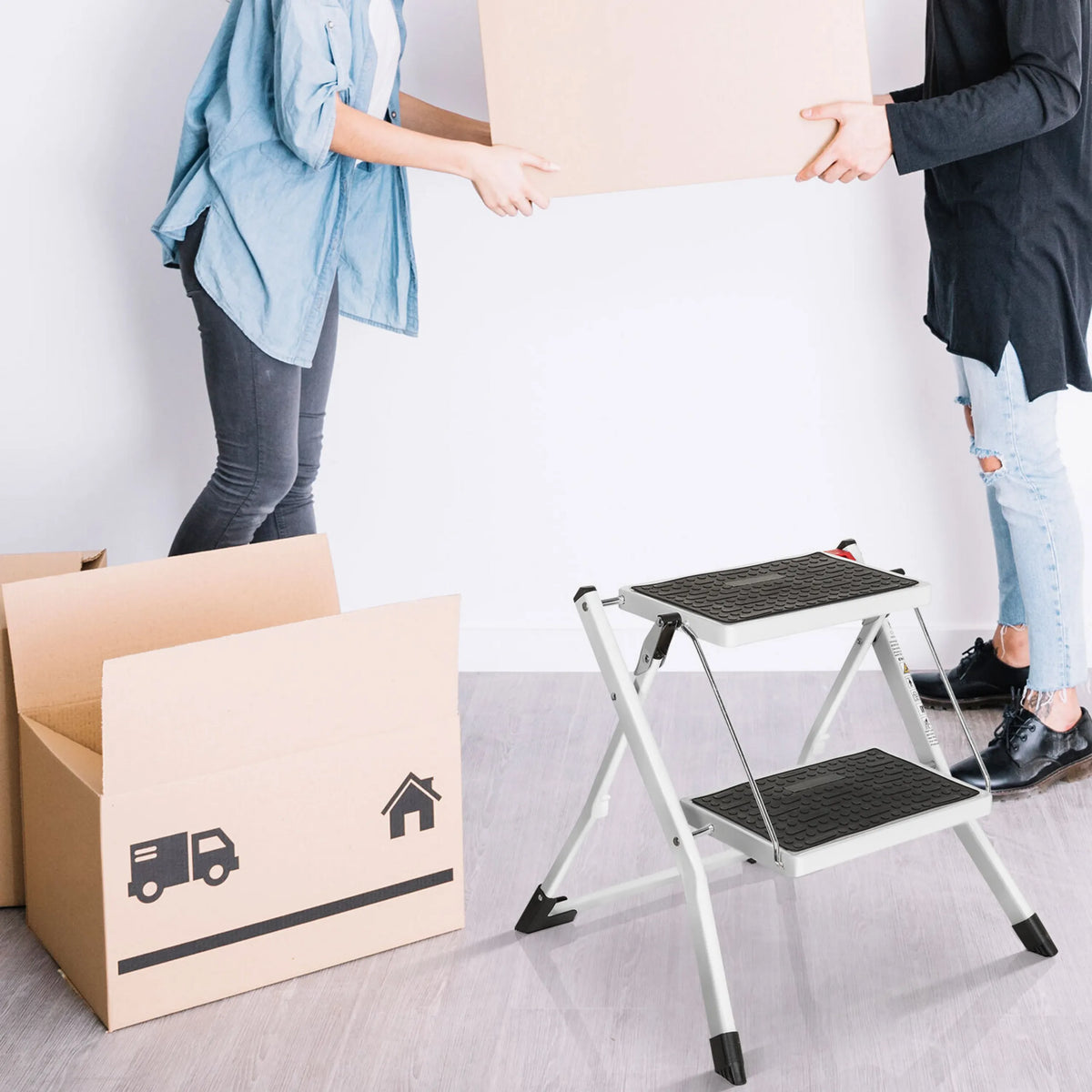 Échelle pliante blanche SOLID W1 avec deux marches noires à côté d'un carton de déménagement de hjh OFFICE