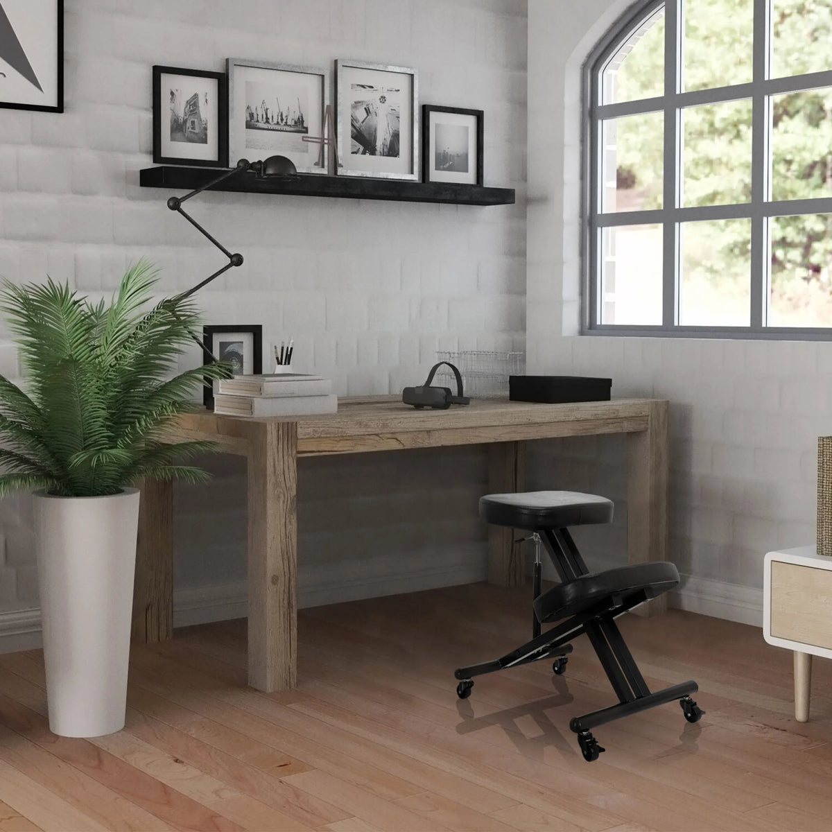 Tabouret à genoux ORTHONI noir avec roulettes devant un bureau en bois dans une pièce lumineuse de hjh OFFICE