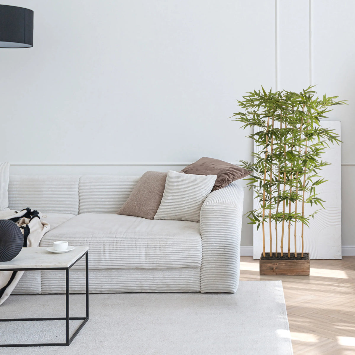 Plante artificielle verte BAMBUS I dans un cache-pot en bois à côté d'un canapé blanc de hjh OFFICE