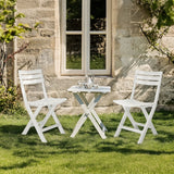 Zwei weiße Outdoor Stühle TRAVANO mit passendem Klapptisch auf einer Rasenfläche von hjh LIVING