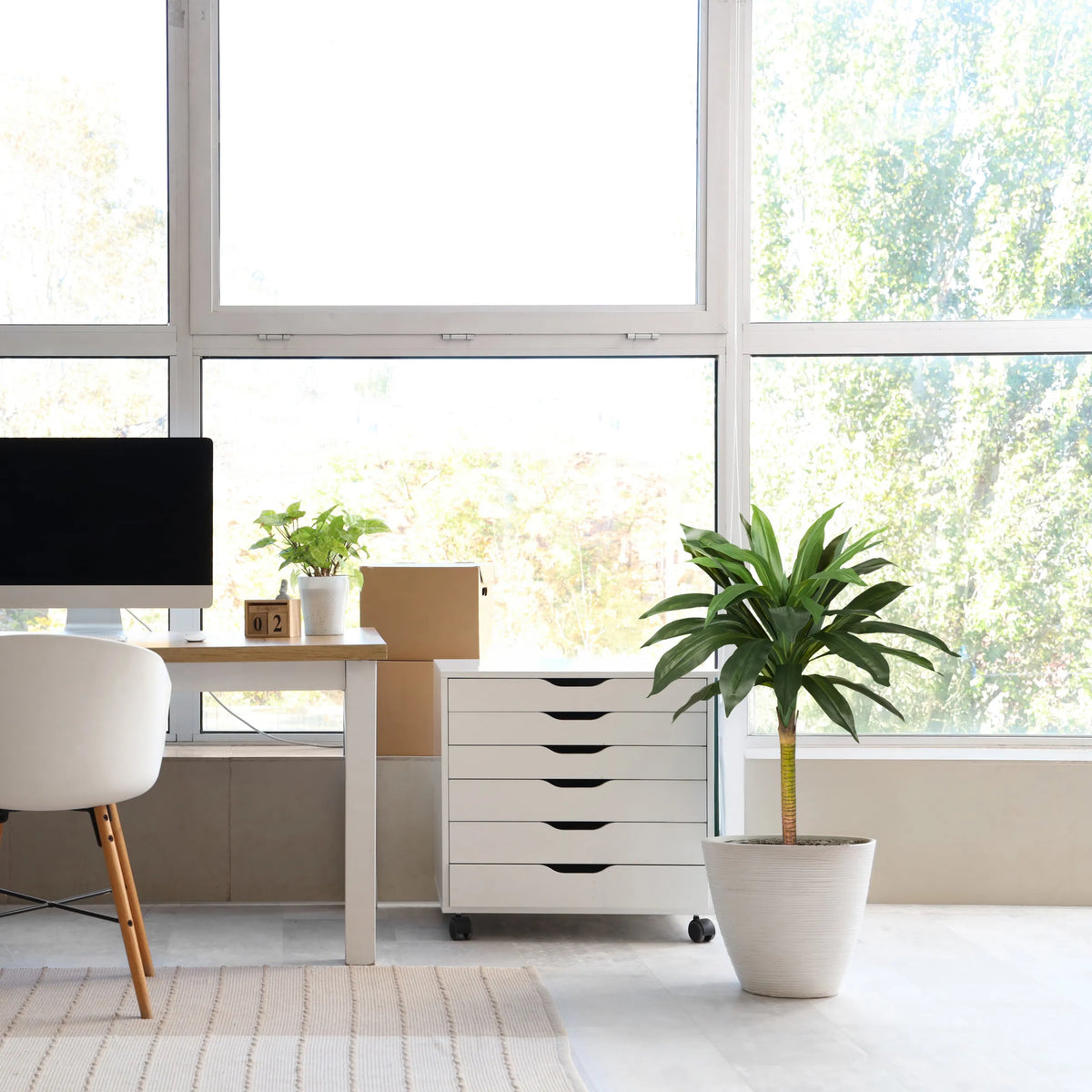Plante artificielle DRACAENA I verte avec un cache-pot blanc dans une pièce lumineuse de hjh OFFICE