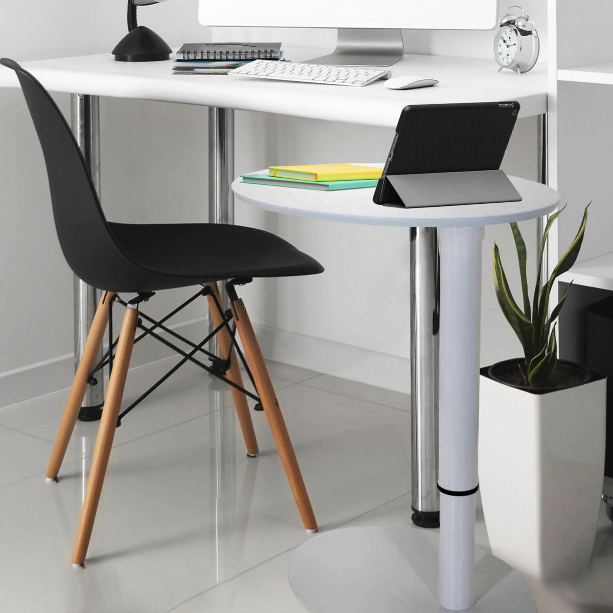 Bureau assis-debout blanc STAND III avec surface de rangement ronde, chaise noire et une plante d'intérieur de hjh OFFICE