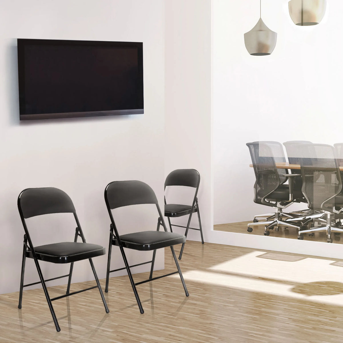 Trois chaises pliantes TUDELA noires avec revêtement en similicuir dans une pièce de hjh OFFICE