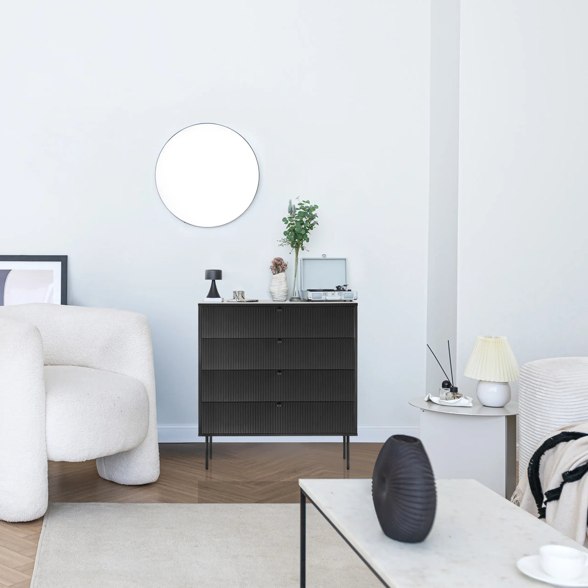 Commode noire KARBY K avec trois tiroirs et des pieds métalliques fins dans un espace de vie lumineux de hjh LIVING