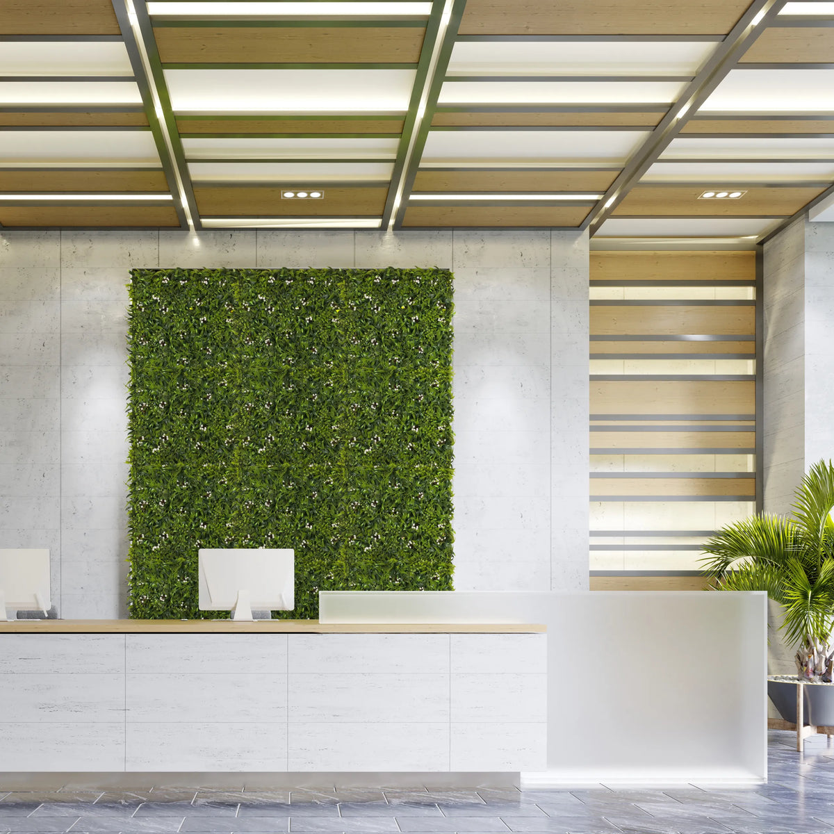 Grüne Pflanzenmatte MORE GREEN I als vertikale Begrünung an einer hellen Betonwand im Empfangsbereich von hjh OFFICE