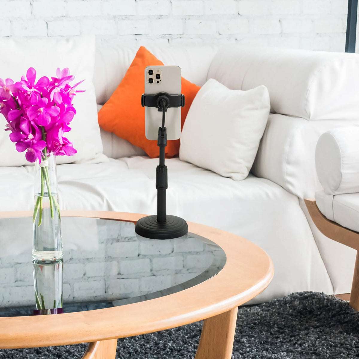 Support de téléphone portable & tablette FLEXMOBI II noir avec smartphone sur une table en verre devant un canapé blanc de hjh OFFICE