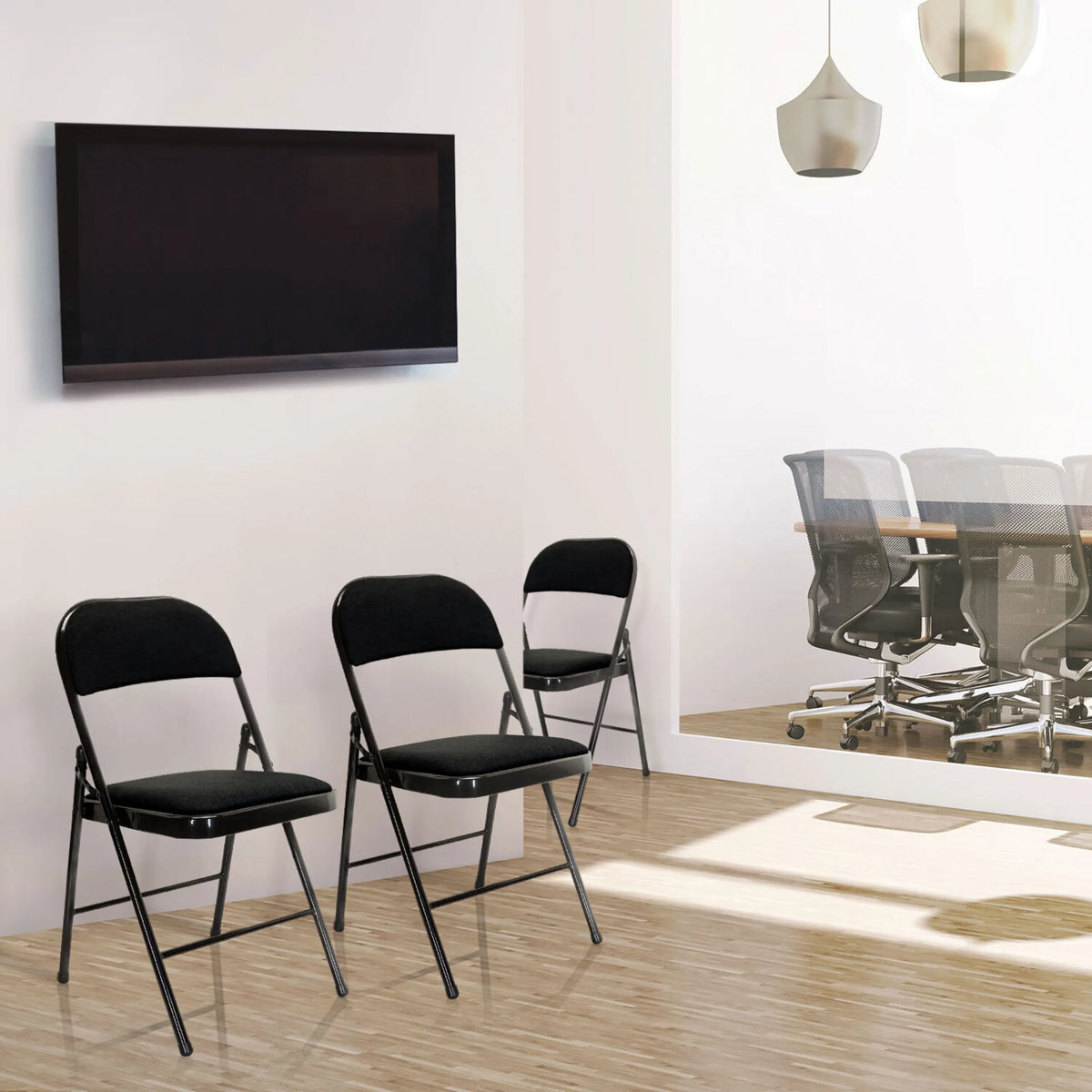 Trois chaises pliantes TUDELA II noires avec housse en tissu dans une pièce de hjh OFFICE